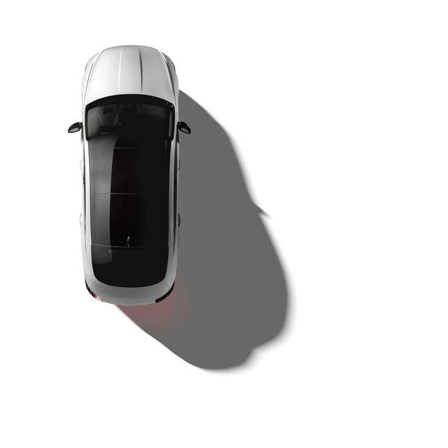 Aerial shot of a white sedan car casting a shadow on a white background.